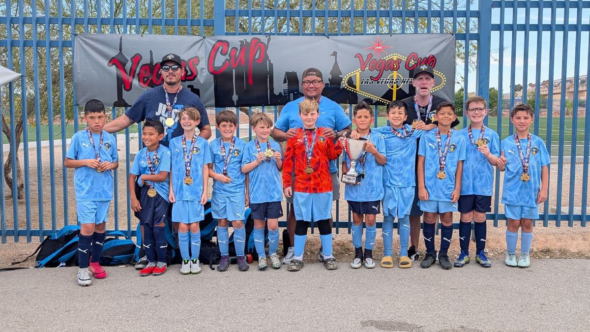 Storm boys team with medals in front of the Vegas Cup banner